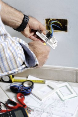 Bir konut elektrik sisteminde çalışan elektrikçi