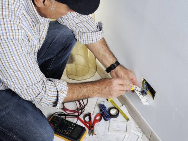 Bir konut elektrik sisteminde çalışan elektrikçi