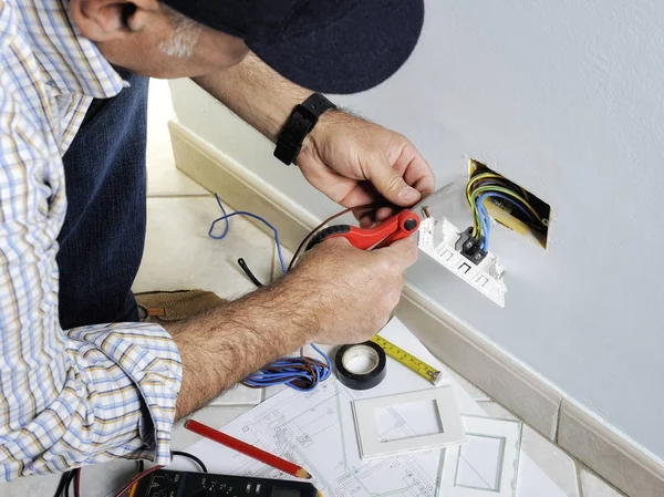 Eletricista trabalhando em um sistema elétrico residencial — Fotografia de Stock