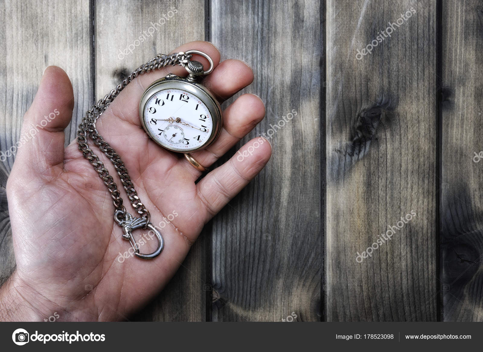 Hombre adulto sosteniendo un reloj de bolsillo antiguo en su mano