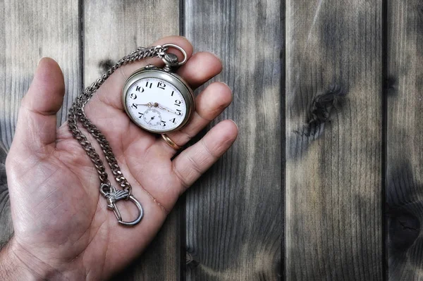 Hombre adulto sosteniendo un reloj de bolsillo antiguo en su mano — Foto de Stock