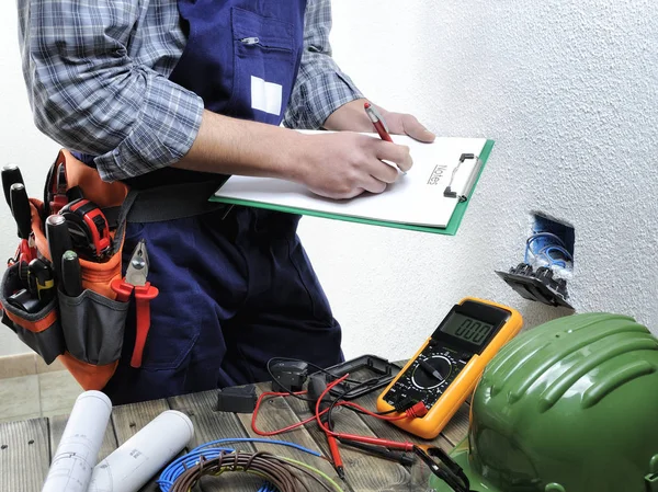 Jovem eletricista trabalhando em uma instalação elétrica residencial — Fotografia de Stock