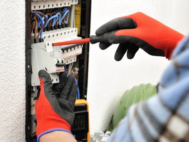 Bir elektrik panel ile iş yerinde genç Elektrikçi Teknisyen 