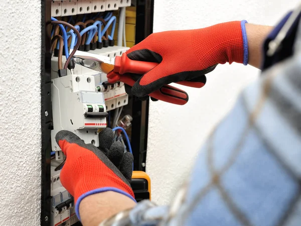 Young electrician technician at work on a electrical panel with — Stock Photo, Image
