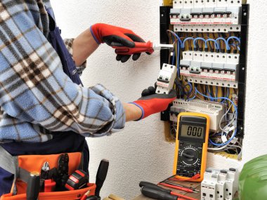 Bir elektrik panel ile iş yerinde genç Elektrikçi Teknisyen 