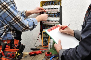 Genç teknisyen elektrikçi ve mühendis kontrol voltajı bir