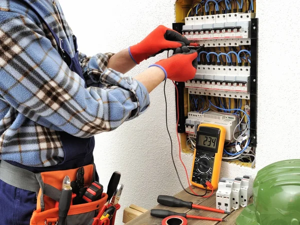 Jonge elektricien technicus aan het werk op een elektrisch paneel met — Stockfoto