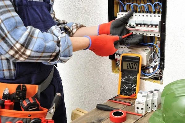 Jovem eletricista técnico no trabalho em um painel elétrico com — Fotografia de Stock