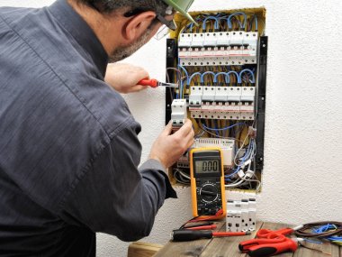 Elektrikçi Teknisyen bir resid koruyucu kask ile iş yerinde