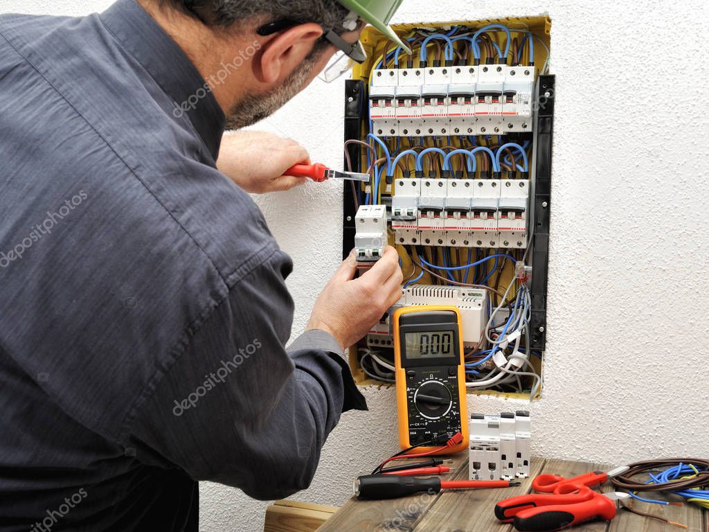 Electrician technician at work with protective helmet on a resid