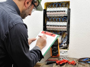 Elektrikçi Teknisyen bir resid koruyucu kask ile iş yerinde