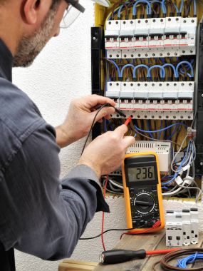 Elektrikçi Teknisyen bir resid koruyucu kask ile iş yerinde