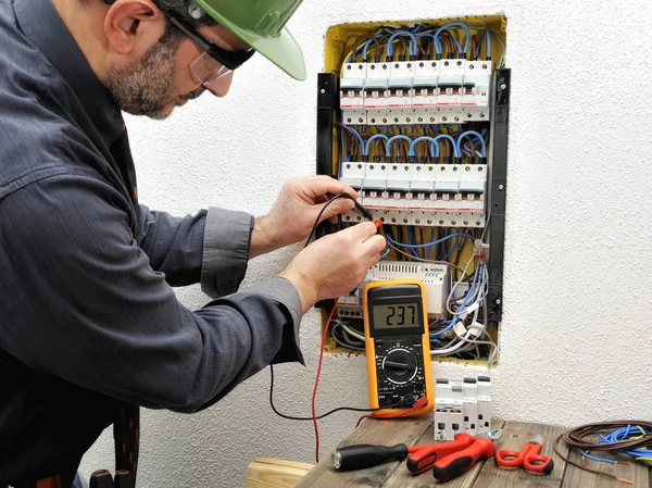 Técnico de eletricista no trabalho com capacete protetor em uma residência — Fotografia de Stock