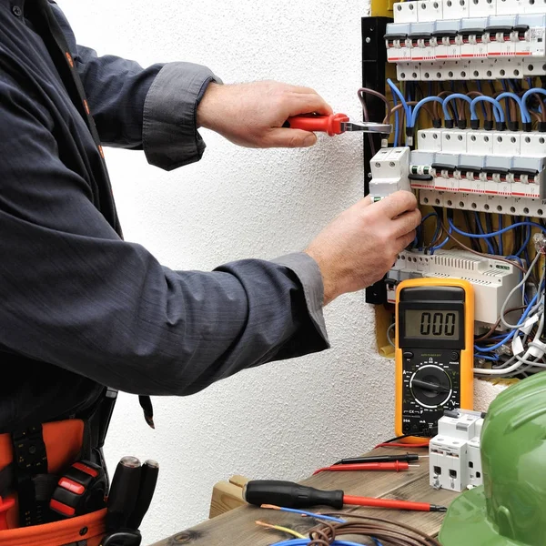 Técnico eletricista elegante no trabalho em um elétrico residencial — Fotografia de Stock