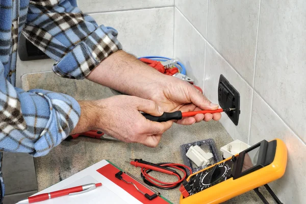 Técnico electricista trabajando en un sistema eléctrico residencial . — Foto de Stock