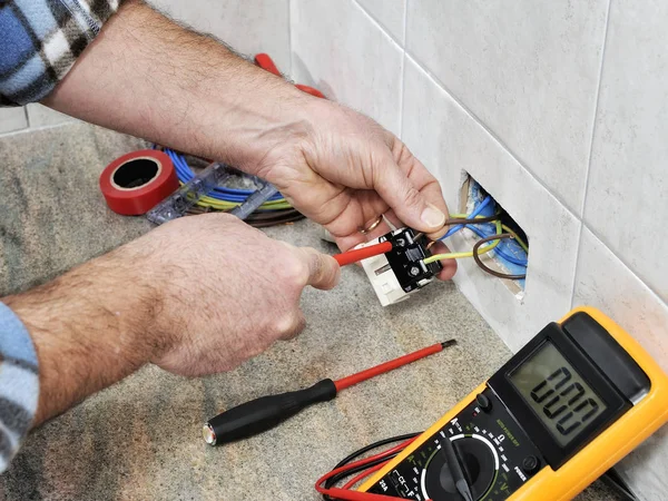 Técnico electricista trabajando en un sistema eléctrico residencial . — Foto de Stock