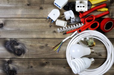 Ahşap arka plan üzerinde iş araçları ve elektrik sistemi bileşenleri Üstten Görünüm