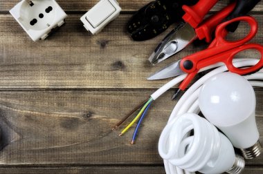 Ahşap arka plan üzerinde iş araçları ve elektrik sistemi bileşenleri Üstten Görünüm
