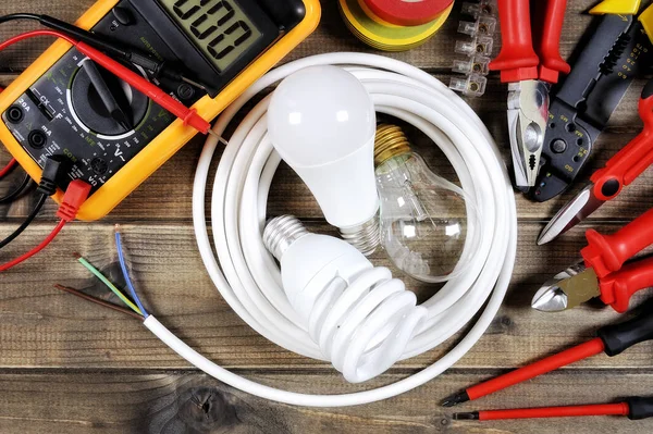 Vista superior de herramientas de trabajo y componentes del sistema eléctrico sobre fondo de madera antiguo . — Foto de Stock