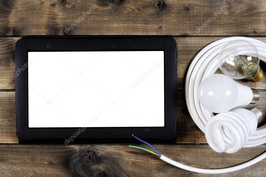 Top view of a laptop and electrical system components on ancient wood background.