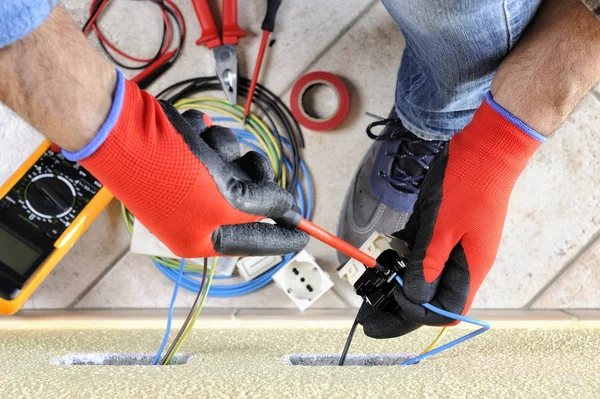 Tecnico elettricista al lavoro con apparecchiature di sicurezza su un impianto elettrico residenziale — Foto Stock