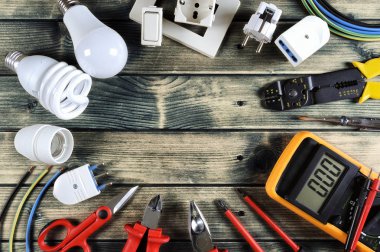 Rustik ahşap arka plan üzerinde iş araçları ve elektrik sistemi bileşenleri Üstten Görünüm