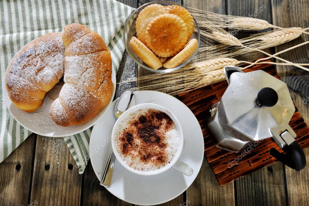 Traditional Italian breakfast with cappuccino and ...