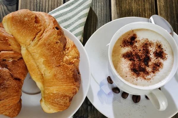 Hagyományos olasz reggeli kapucsínót és croissant-t, egy rusztikus, fából készült asztal — Stock Fotó