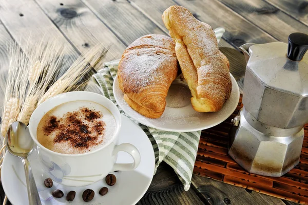 Hagyományos olasz reggeli kapucsínót és croissant-t, egy rusztikus, fából készült asztal — Stock Fotó