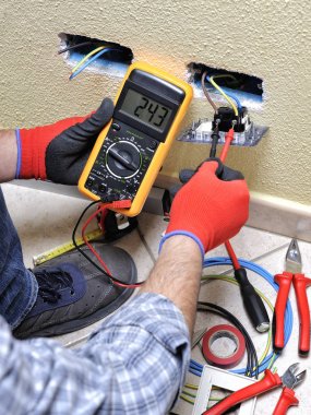 Electrician technician at work with safety equipment on a residential electrical system clipart
