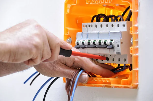 Técnico de eletricista trabalhando em um painel elétrico residencial — Fotografia de Stock