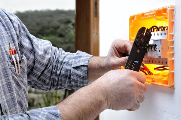 Electrician technician repairs the electrical panel of a residential system