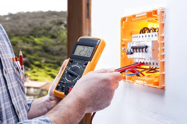 Électricien technicien répare le panneau électrique d'un système résidentiel — Photo