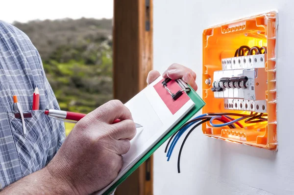 Técnico eletricista repara o painel elétrico de um sistema residencial — Fotografia de Stock