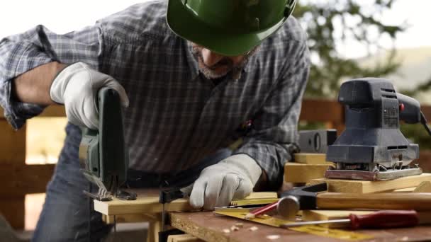 Volwassen Timmerman Met Helm Leren Handschoenen Met Elektrische Zaag Aan — Stockvideo