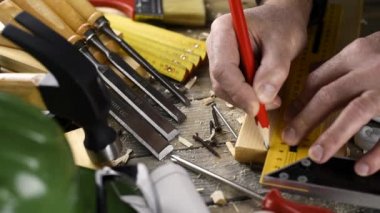 Üst Manzara. Marangoz, tahta bir tahta, kalem ve marangoz karesi ile kesme çizgisini ölçer. İnşaat endüstrisi, kendin yap. Ahşap çalışma masası.