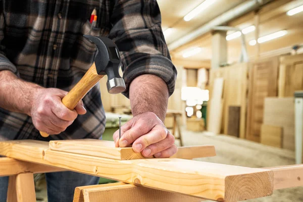 Carpintero en el trabajo sobre tablas de madera. Carpintería . — Foto de Stock