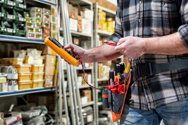 Electrician in the store of electrical components. Electricity. — Stock Photo, Image