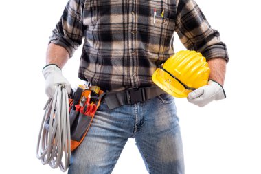 Elektrikçi, koruyucu gözlüklü bir kaskla elektrik kablosunu elinde tutuyor. İnşaat endüstrisi, elektrik sistemi. Beyaz bir arkaplanda izole edilmiş.