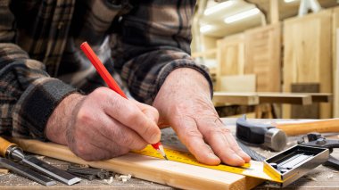 Yakın plan. Kalem ve marangoz meydanlı marangoz tahta bir tahta üzerine kesik çizgisi çiziyor. İnşaat endüstrisi, marangozluk atölyesi.