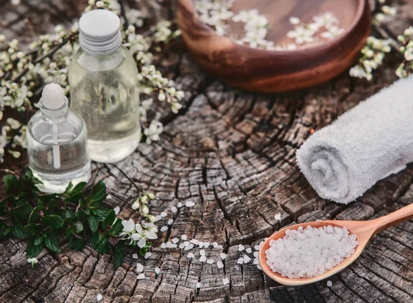 Spa and wellness setting with sea salt, oil essence, flowers and — Stock Photo, Image