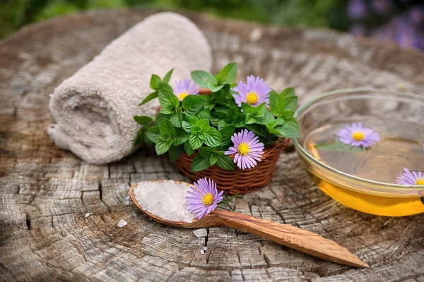 Spa e bem-estar com sal marinho, essência de óleo, flores e — Fotografia de Stock