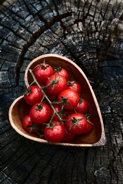 Tomates cherry en forma de corazón placa en la superficie de madera vieja, spac — Foto de Stock