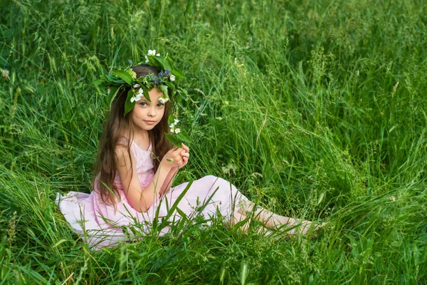 Linda menina em um vestido branco posando na grama — Fotografia de Stock