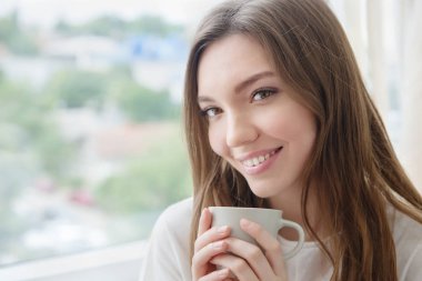 Bir fincan kahve ya da çay getiren genç bir kadın..