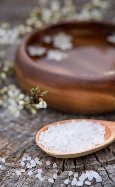 Spa and wellness setting with sea salt, oil essence, flowers and