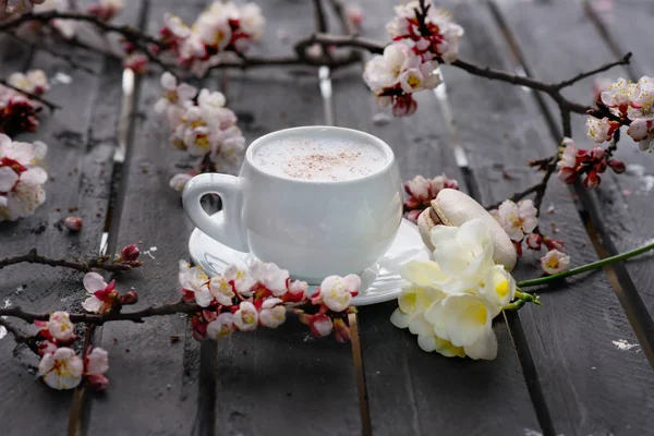 Copa de café caliente con galletas de macarrones y flores de primavera en t —  Fotos de Stock