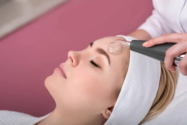 Mujer recibiendo tratamiento facial rejuvenecedor de limpieza en una belleza —  Fotos de Stock