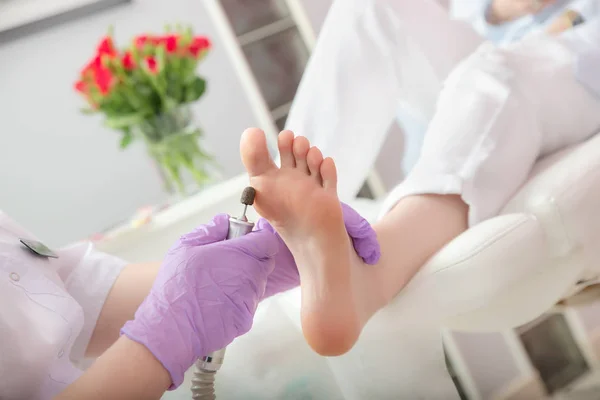 Peeling feet pedicure procedure with eletric device in the beau — 스톡 사진