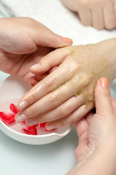 Woman hands in a nail salon receiving a  hand massage by a beaut